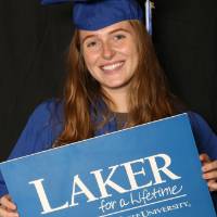 graduating student with Laker for a Lifetime sign